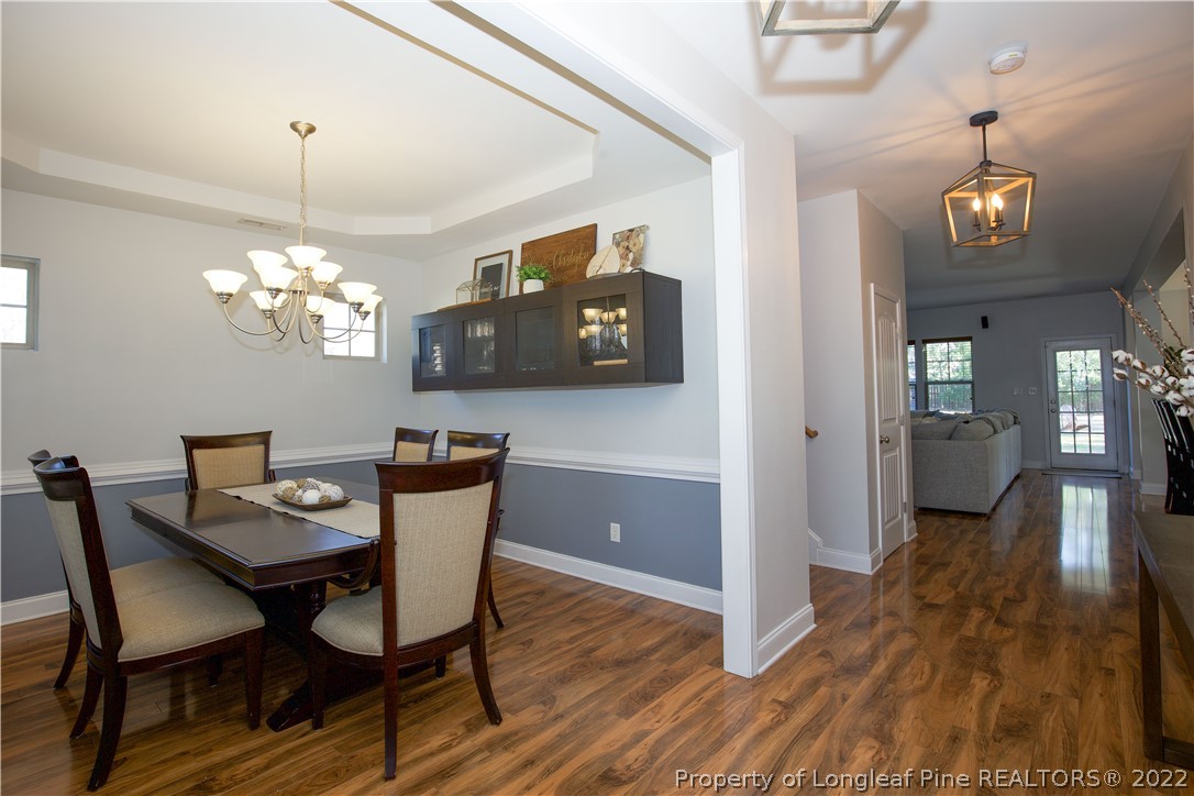 747 Sun Road Aberdeen, NC 28315 - Photo 7 of 48 a view of a dining room with furniture a chandelier and wooden floor