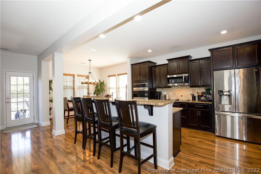 747 Sun Road Aberdeen, NC 28315 - Photo 8 of 48 a kitchen with kitchen island granite countertop stainless steel appliances a dining table and chairs
