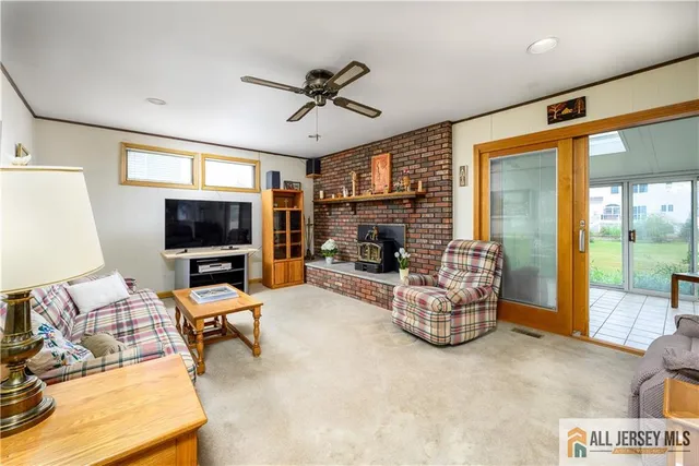 a living room with furniture a flat screen tv and a large window