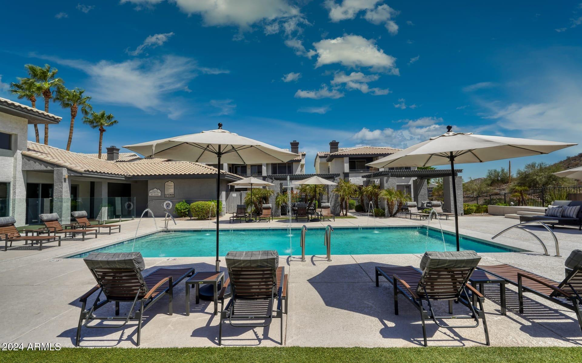 3625 East Ray Road, Unit 1 Phoenix, AZ 85044 - Photo 26 of 29 a view of a patio with table and chairs under an umbrella