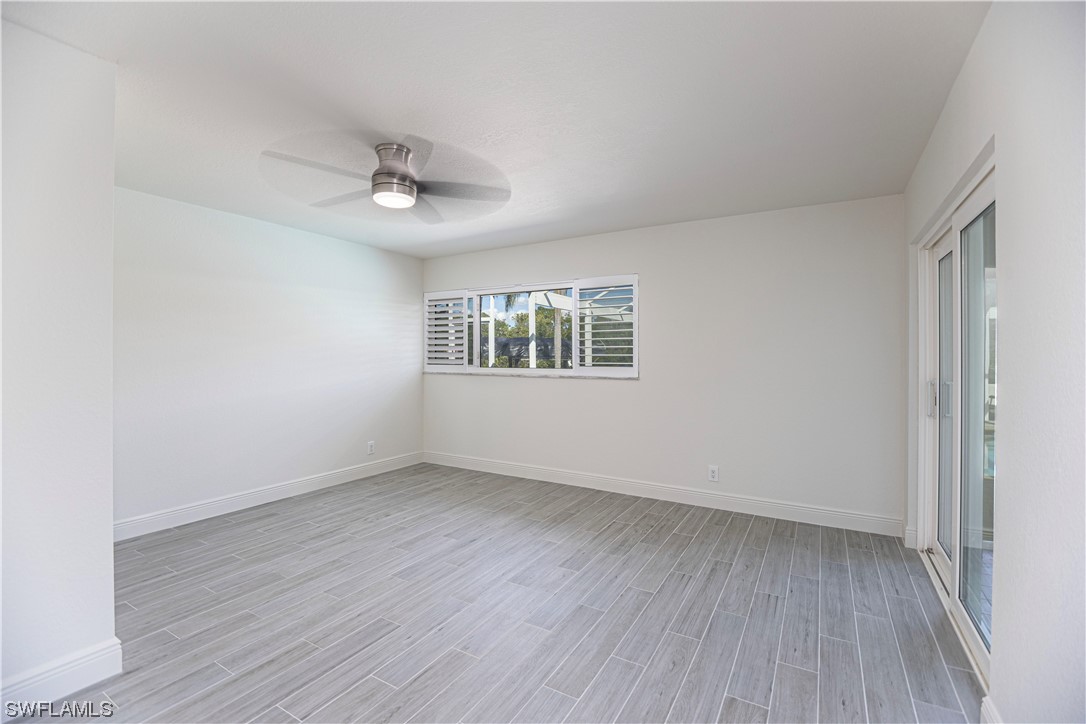 1753 Club House Road North Fort Myers, FL 33917 - Photo 19 of 24 an empty room with wooden floor ceiling fan and windows