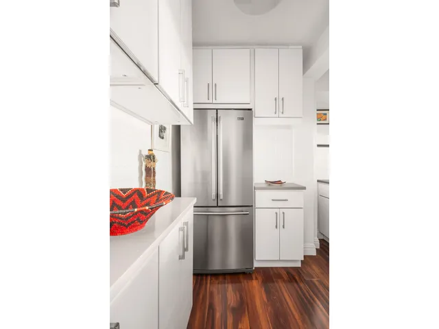 a kitchen with kitchen island granite countertop white cabinets and white appliances