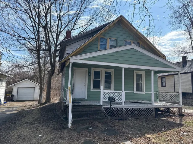 a front view of a house with a garden and trees