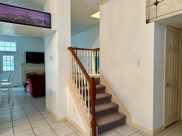 a view of a hallway with wooden floor and staircase