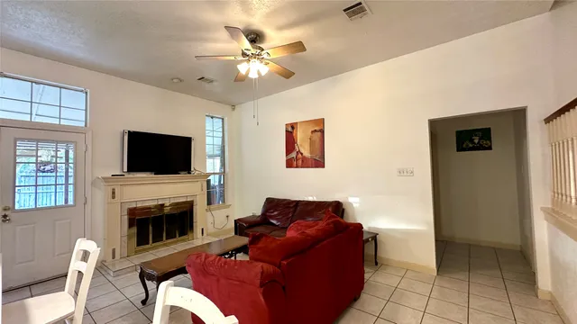 a living room with furniture a flat screen tv and a fireplace