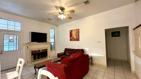 a living room with furniture a flat screen tv and a fireplace