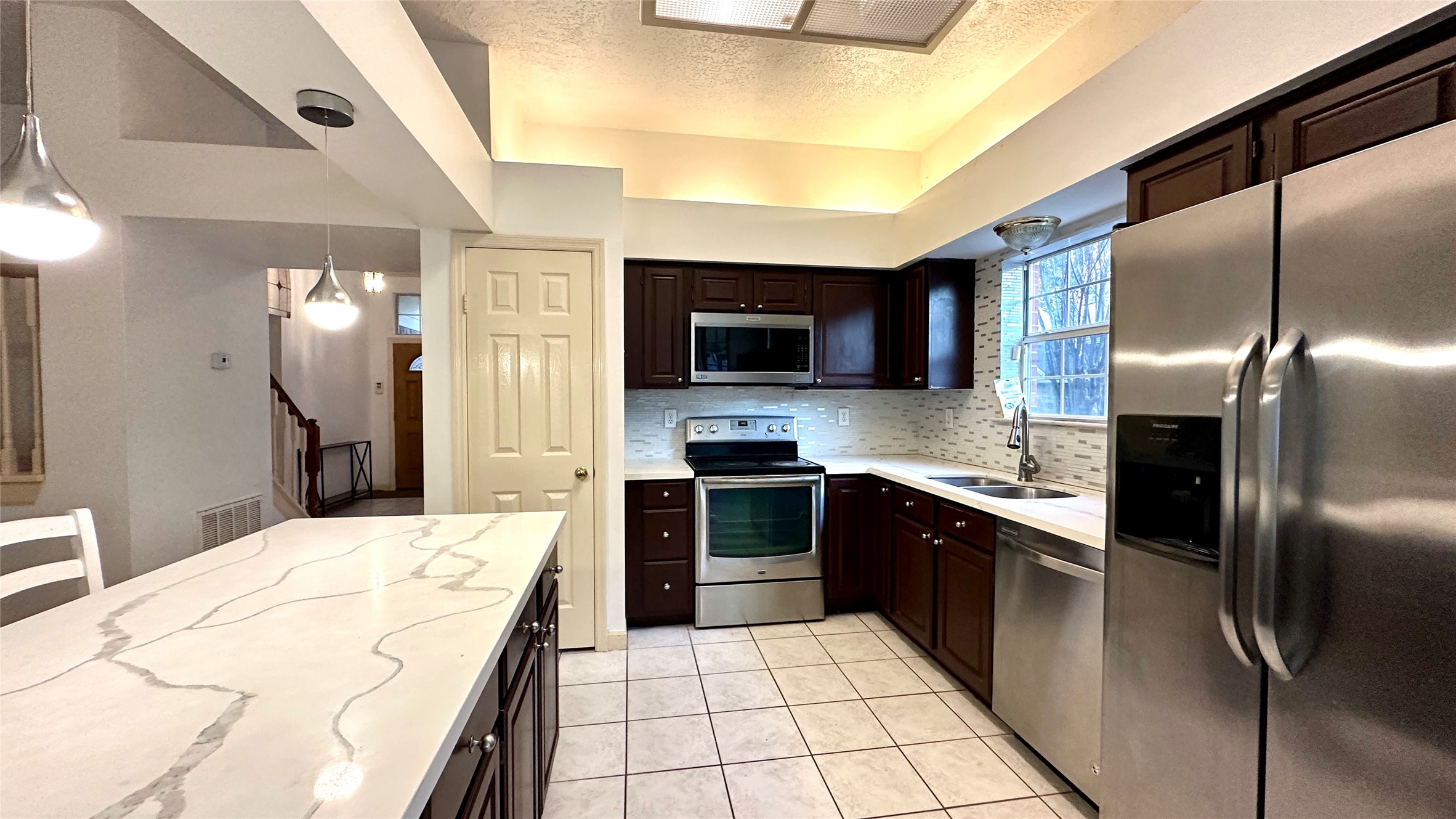 6918 Springcrest Court Sugar Land, TX 77479 - Photo 6 of 29 a large kitchen with a large counter top stainless steel appliances and cabinets