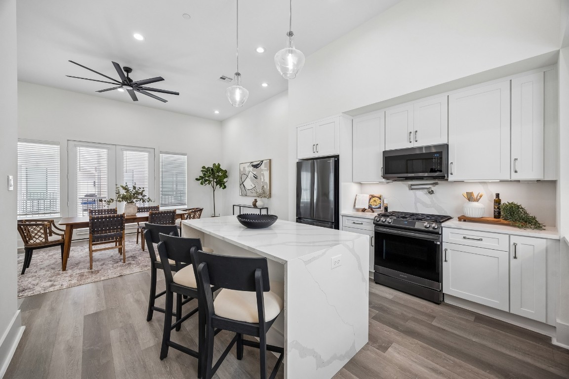 Sleek gourmet kitchen features a quartz waterfall kitchen island with plenty of extra seating and storage.