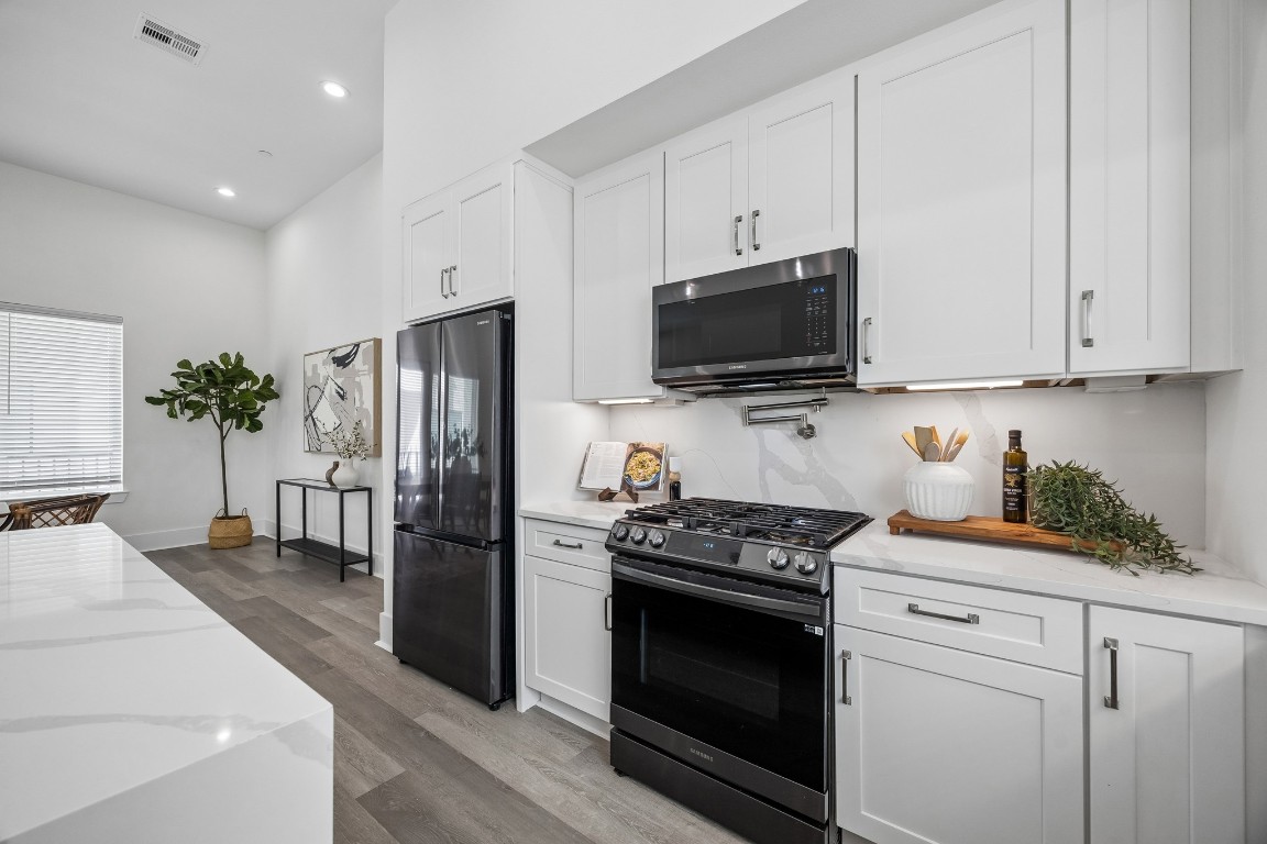 1618 Ojeman Road, Unit A Houston, TX 77055 - Photo 9 of 39 The kitchen has a French door refrigerator and black toned appliances.