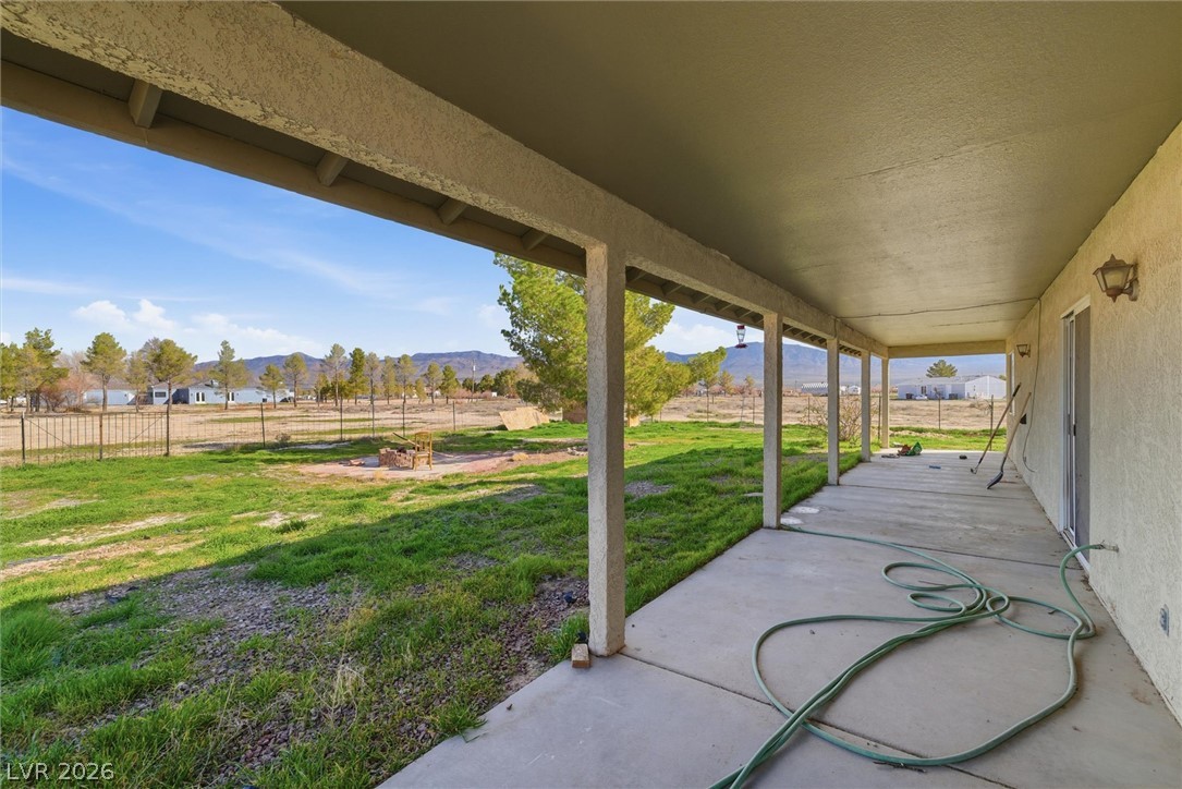 2780 West Simkins Road Pahrump, NV 89060 - Photo 33 of 40 A spacious covered patio overlooks a generous grassy yard with distant mountain views.