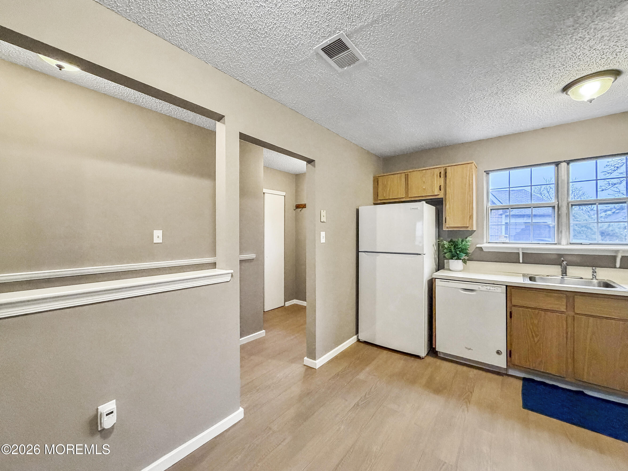47 Carnaby Close Freehold, NJ 07728 - Photo 6 of 29 a kitchen with a refrigerator a sink and dishwasher with white cabinets