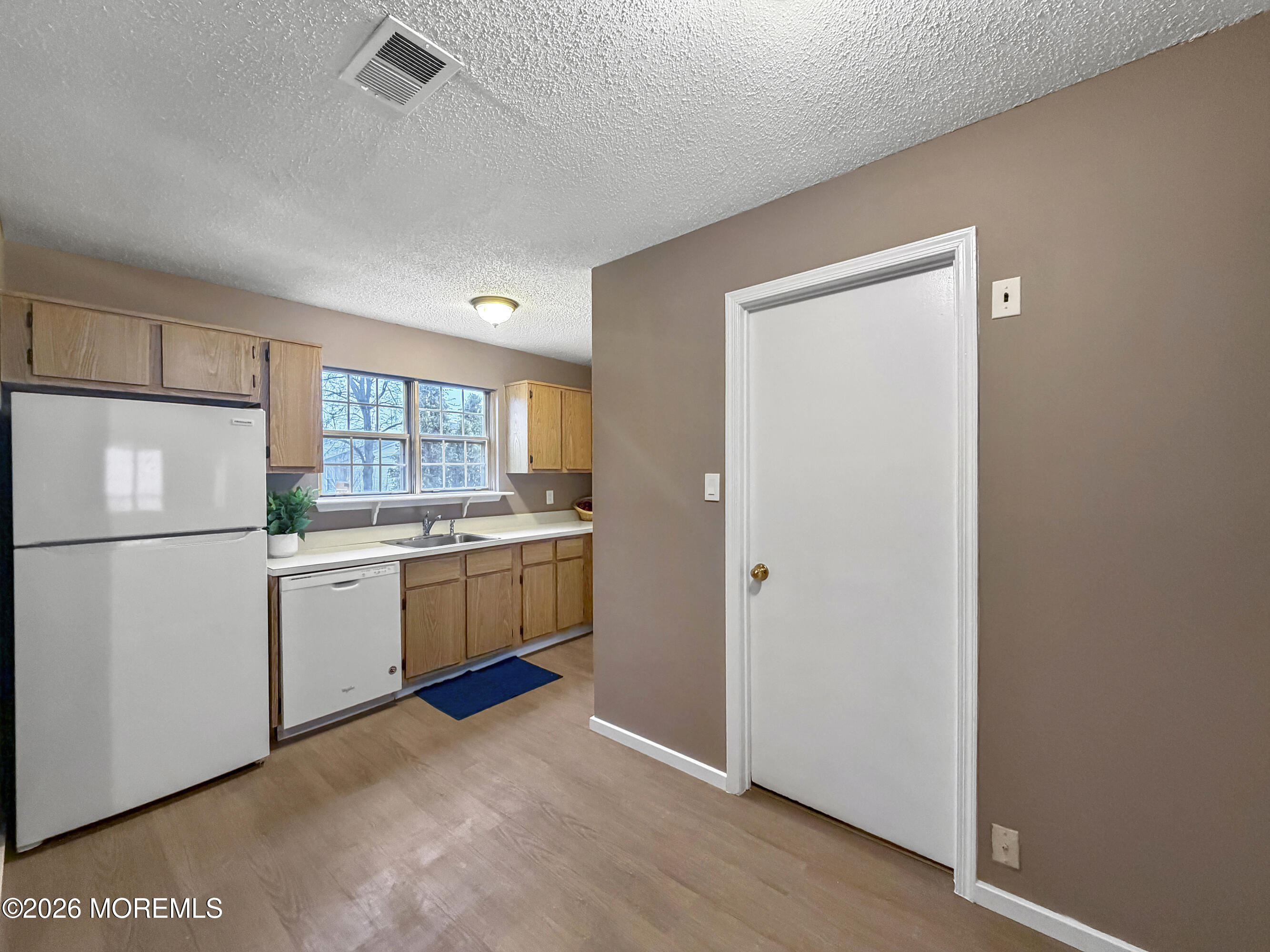 47 Carnaby Close Freehold, NJ 07728 - Photo 7 of 29 a kitchen with a refrigerator and white cabinets