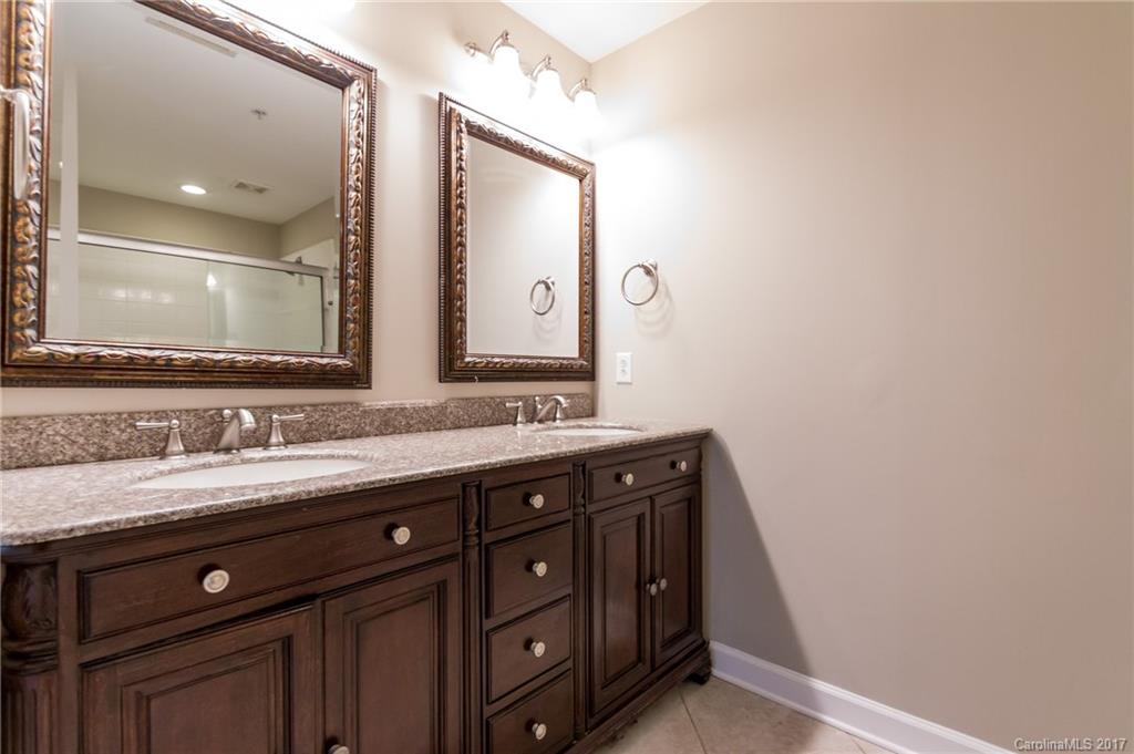 718 West Trade Street, Unit 211 Charlotte, NC 28202 - Photo 14 of 24 a bathroom with a granite countertop sink and a mirror