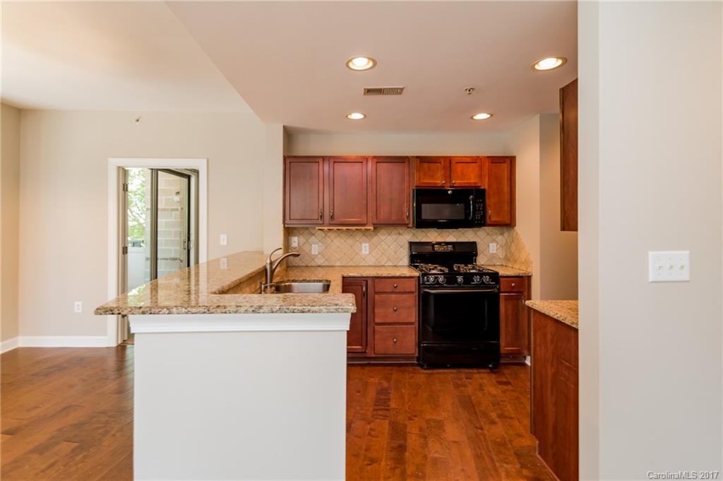 718 West Trade Street, Unit 211 Charlotte, NC 28202 - Photo 8 of 24 a kitchen with stainless steel appliances granite countertop a stove a sink and a refrigerator