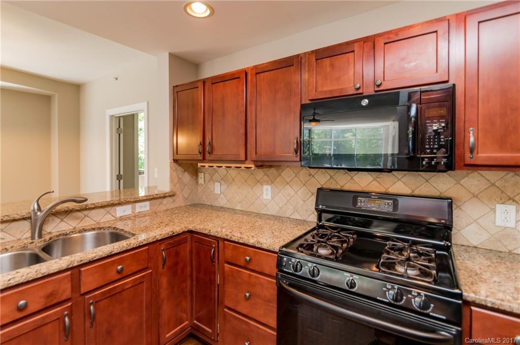 718 West Trade Street, Unit 211 Charlotte, NC 28202 - Photo 9 of 24 a kitchen with granite countertop a stove and a sink