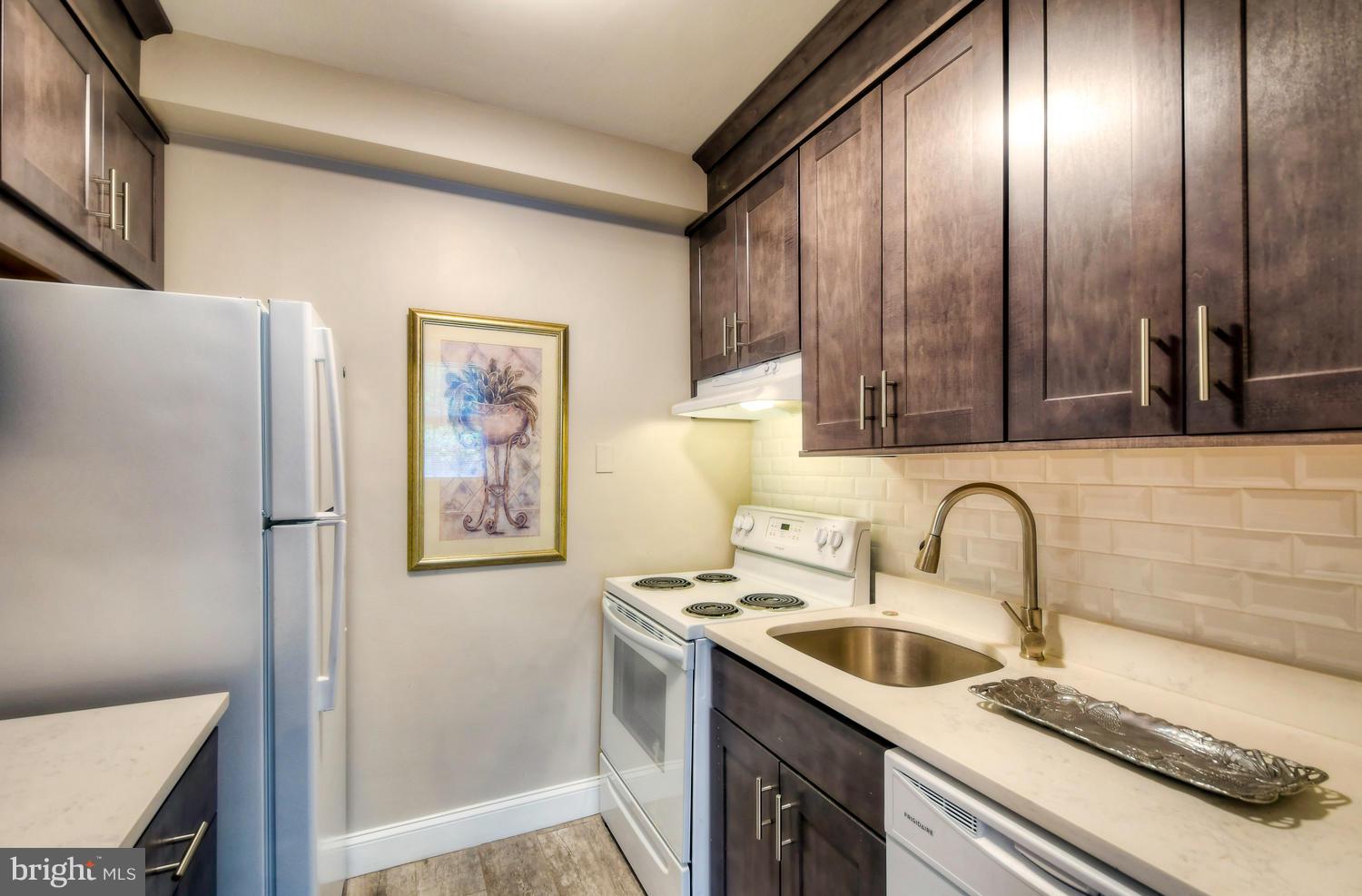 310 Ridgemede Road, Unit 203 Baltimore, MD 21210 - Photo 11 of 18 a kitchen with stainless steel appliances a sink stove and cabinets