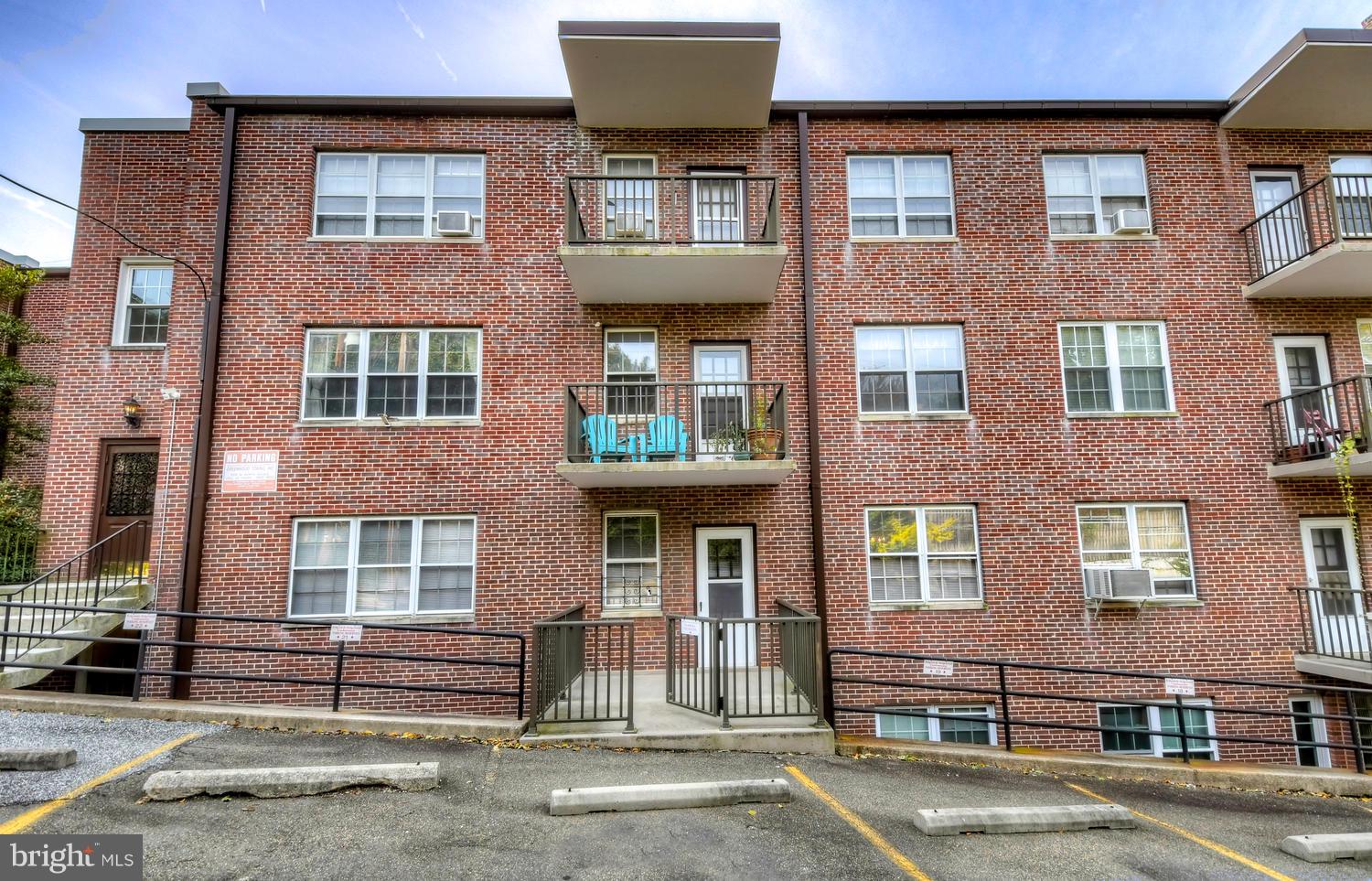 310 Ridgemede Road, Unit 203 Baltimore, MD 21210 - Photo 18 of 18 a front view of a residential apartment building with a yard