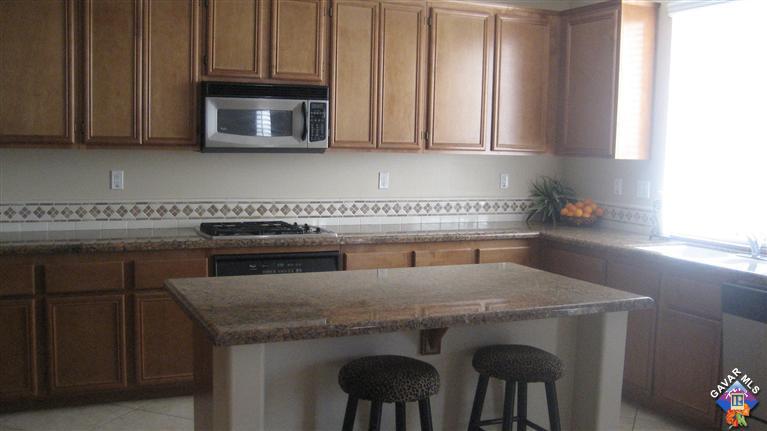44741 Ruthron Avenue Lancaster, CA 93536 - Photo 10 of 18 a kitchen with stainless steel appliances a stove a microwave a sink and cabinets