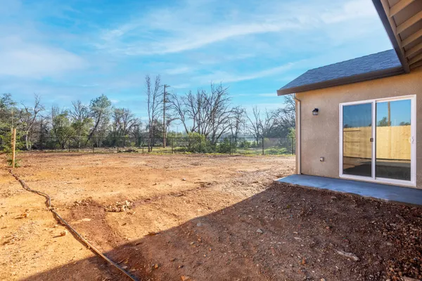 a view of a yard with wooden fence