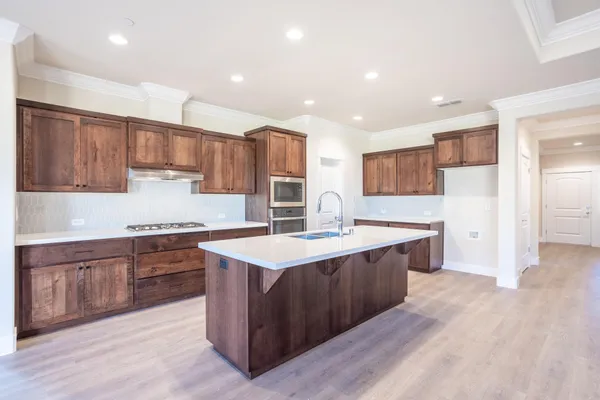 a kitchen with stainless steel appliances granite countertop a sink stove and refrigerator