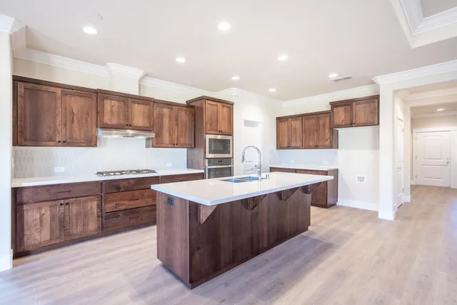 a kitchen with stainless steel appliances granite countertop a sink stove and refrigerator