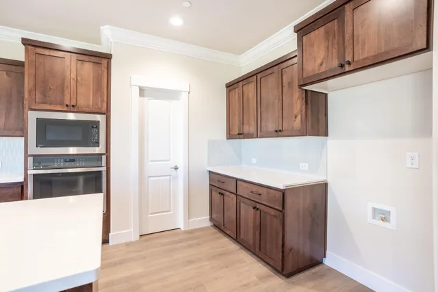 a kitchen with granite countertop a refrigerator and a stove top oven