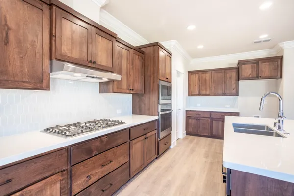 a kitchen with stainless steel appliances granite countertop a sink stove and refrigerator