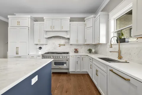 a kitchen with cabinets appliances a sink and a window