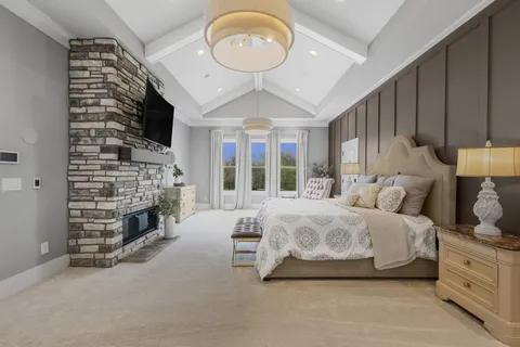 a spacious bedroom with a bed a fireplace and a large window
