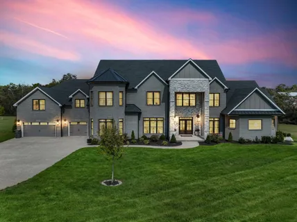 a front view of a house with a yard and trees