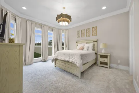 a spacious bedroom with a bed and a chandelier