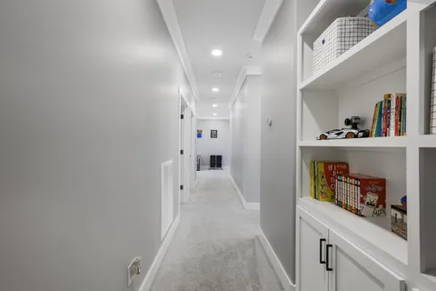 a view of hallway with painting on the wall and a potted plant