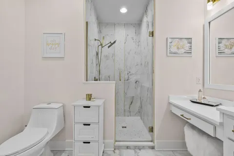 a bathroom with a sink a toilet and shower