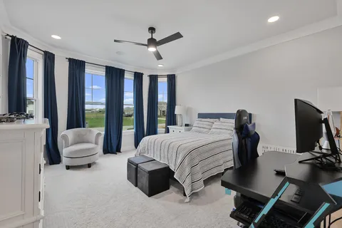 a bedroom with a bed a large window and couch