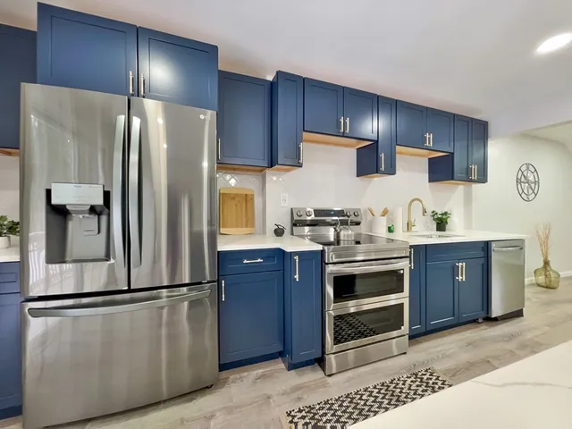 a kitchen with stainless steel appliances a refrigerator and a stove top oven