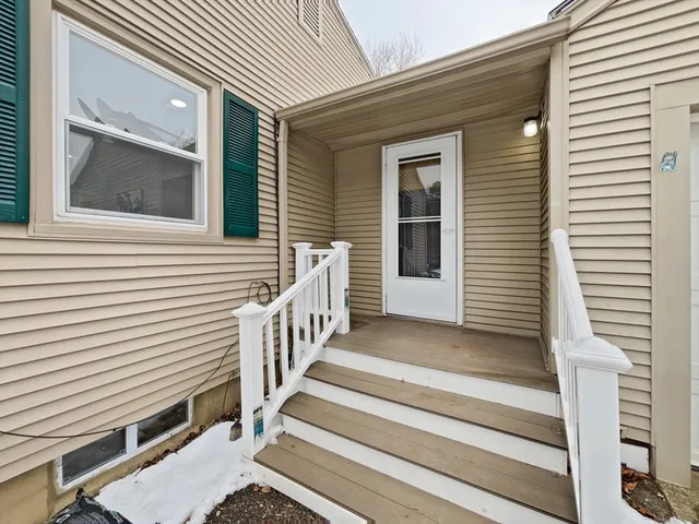 a view of a house with entryway and wooden stairs