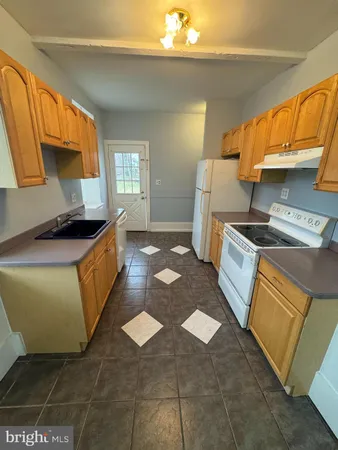 a kitchen with granite countertop a sink a stove and cabinets