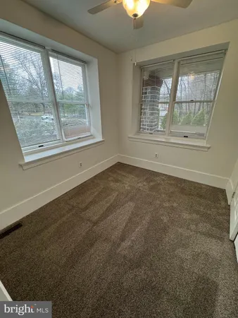en empty room with windows and fan
