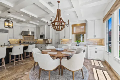 a bedroom with a bed a chandelier and a large window