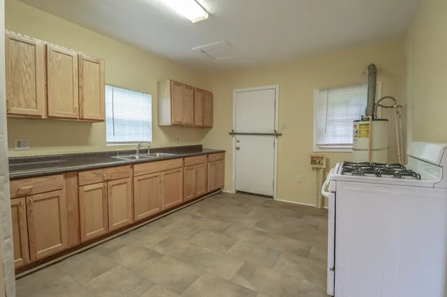 a kitchen with stainless steel appliances granite countertop a stove a sink and a refrigerator