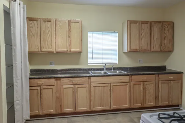 a kitchen with granite countertop white cabinets and sink