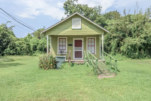 a front view of house with a garden