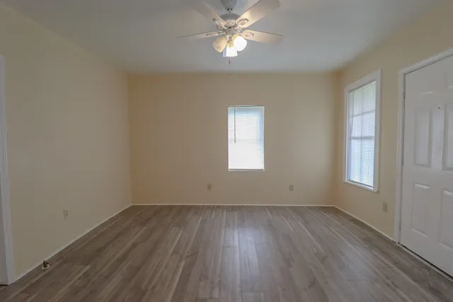 an empty room with a window and wooden floor