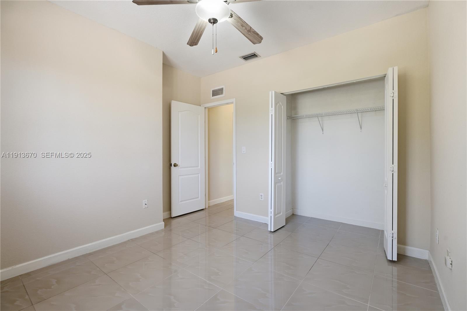 21460 Southwest 85th Passage Cutler Bay, FL 33189 - Photo 12 of 20 an empty room with a ceiling fan and carpet