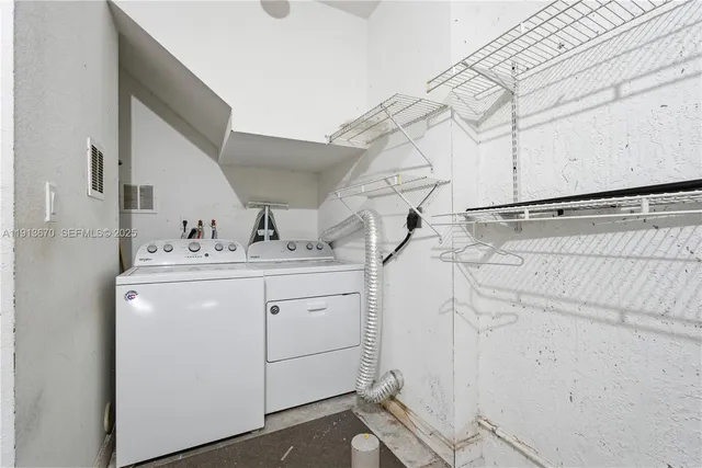 a utility room with cabinets washer and dryer