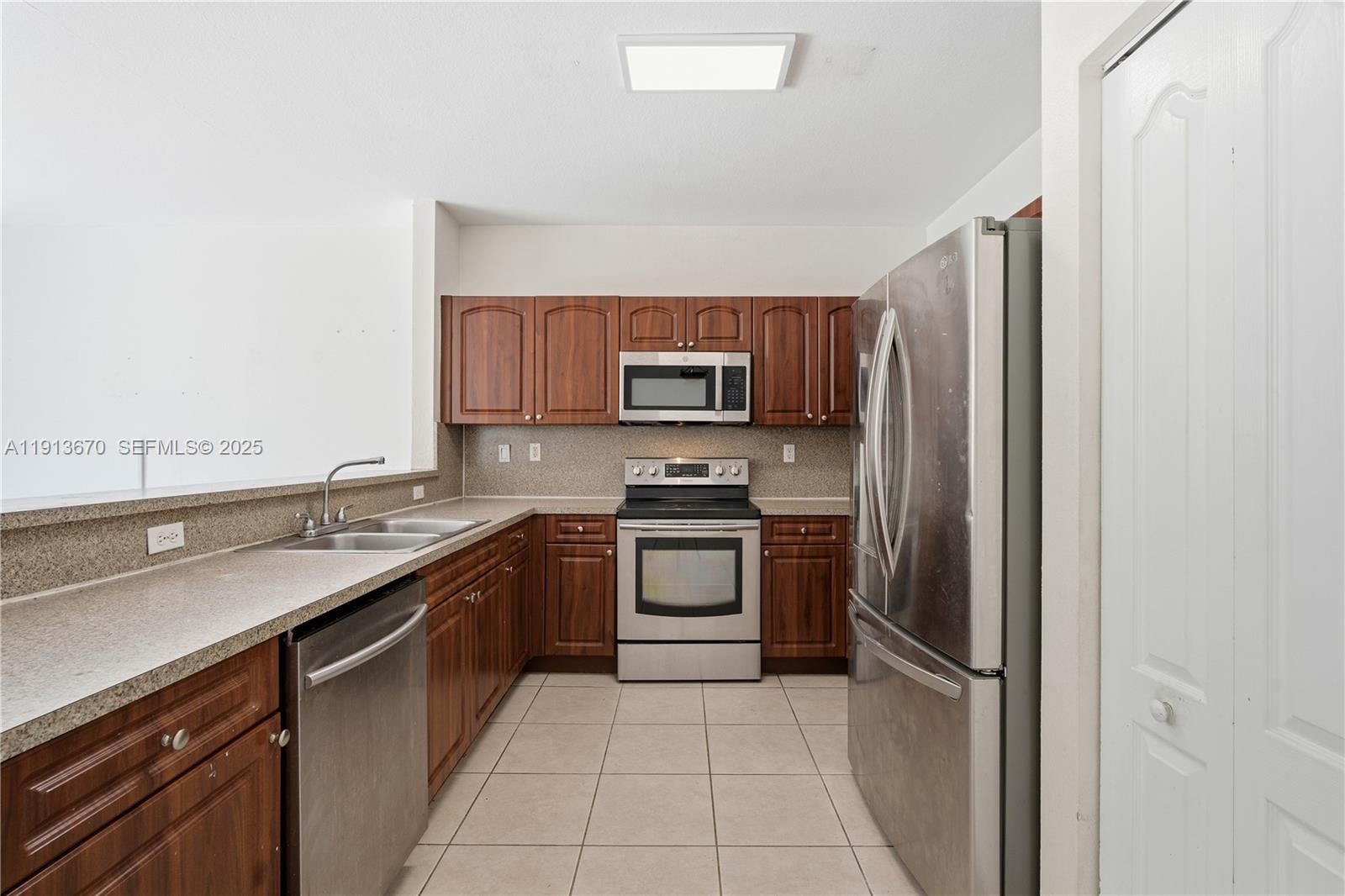 21460 Southwest 85th Passage Cutler Bay, FL 33189 - Photo 6 of 20 a kitchen with stainless steel appliances granite countertop a refrigerator and a sink