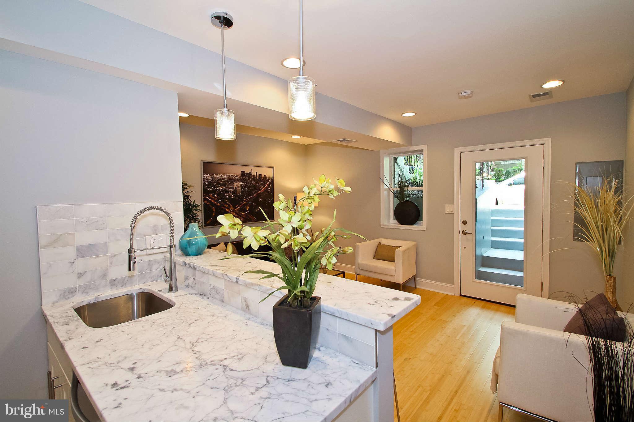 604 Columbia Road Northwest, Unit 1 Washington, DC 20001 - Photo 1 of 17 a kitchen with a sink a faucet and chairs