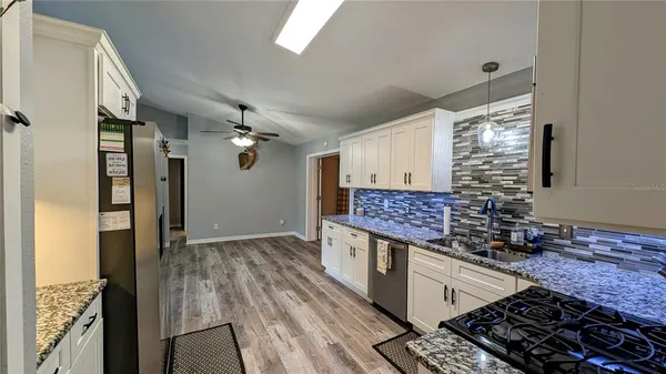 a kitchen with stainless steel appliances granite countertop a refrigerator and a stove