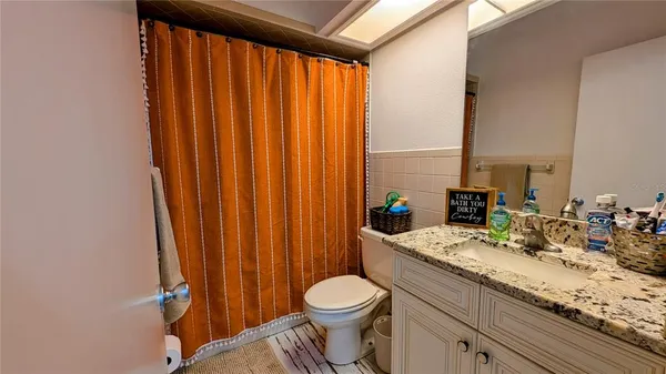a room with a bed and ceiling fan
