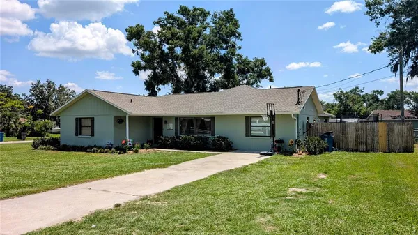 a front view of house with yard and trees in the background